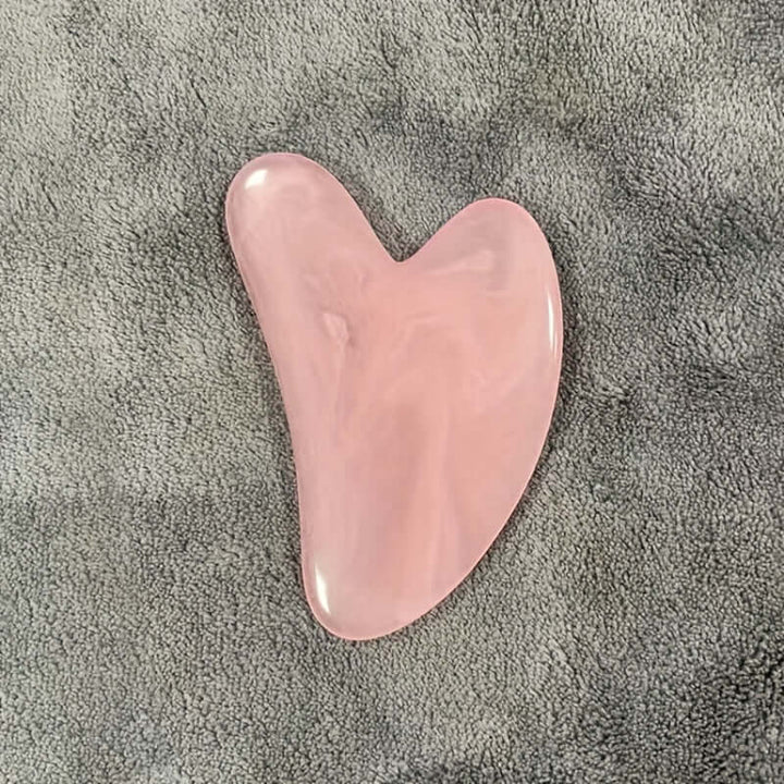 Pastel pink gua sha tool for face and body